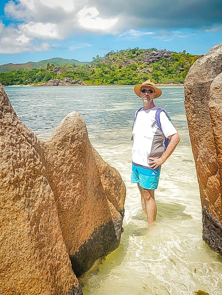 Ben on a bright Seychelle morning among the weathered granite rocks characteristic of the seychelles