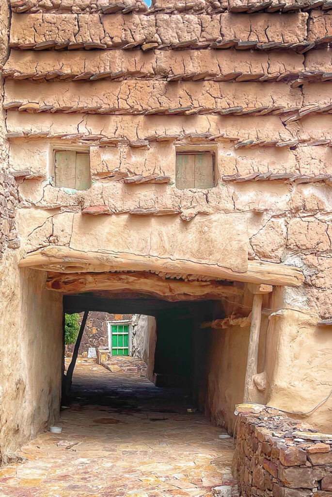 A picture during a walk through an old village.  The horizontal rocks set into the walls are typical of this region and are to help keep the rain from running down the mud exterior.